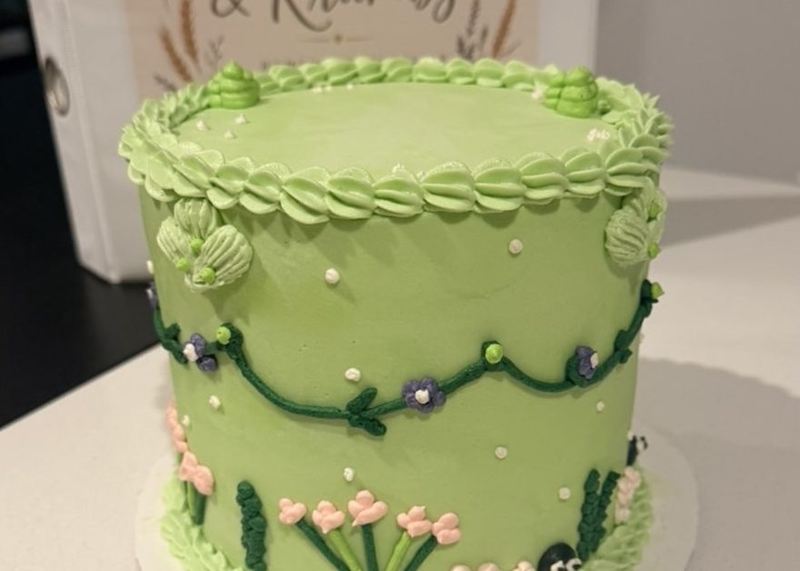 Soft green cake piped with trailing vines and small flowers