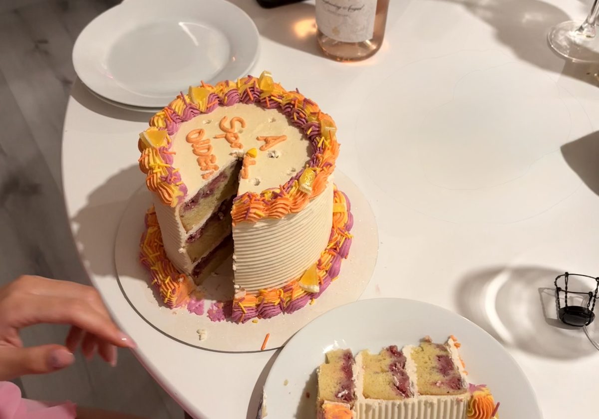 The pink and orange cake cut open, with a slice served on a plate