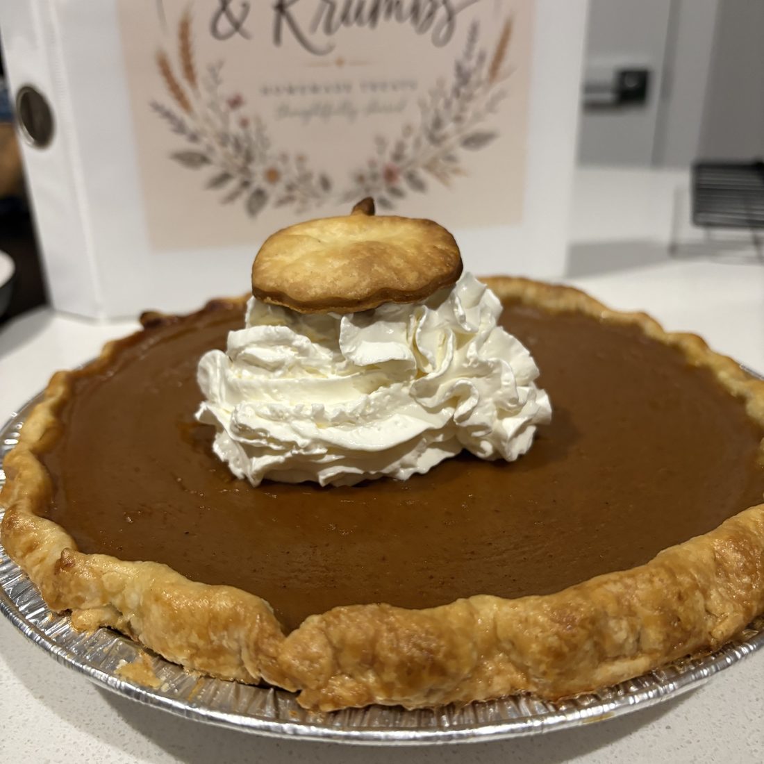 Whole pumpkin pie topped with fresh whipped cream